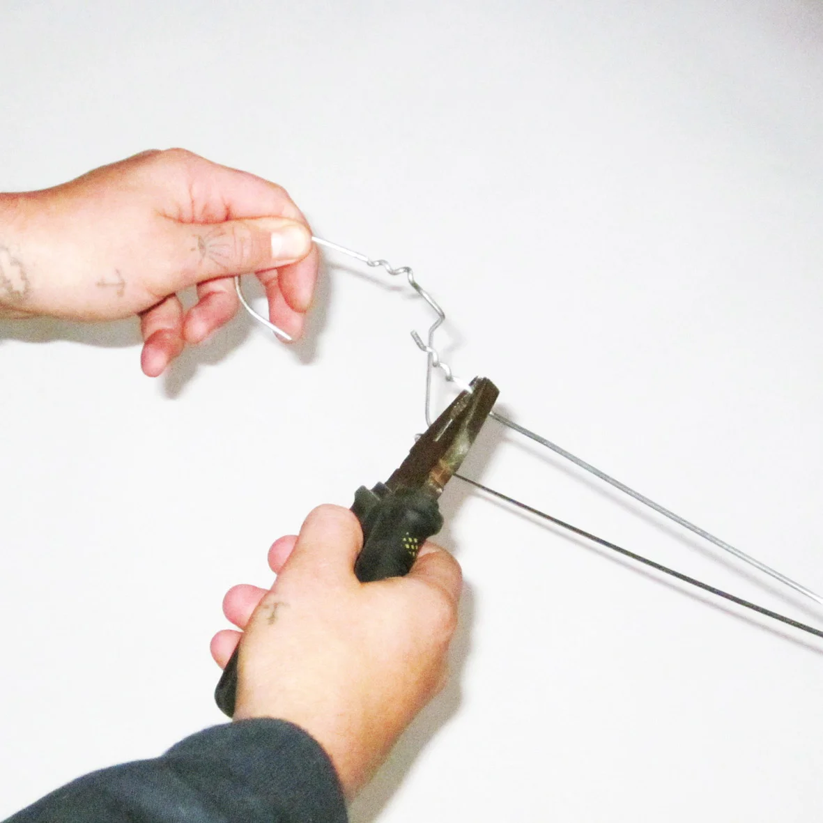 With the pliers straighten out the coat hanger