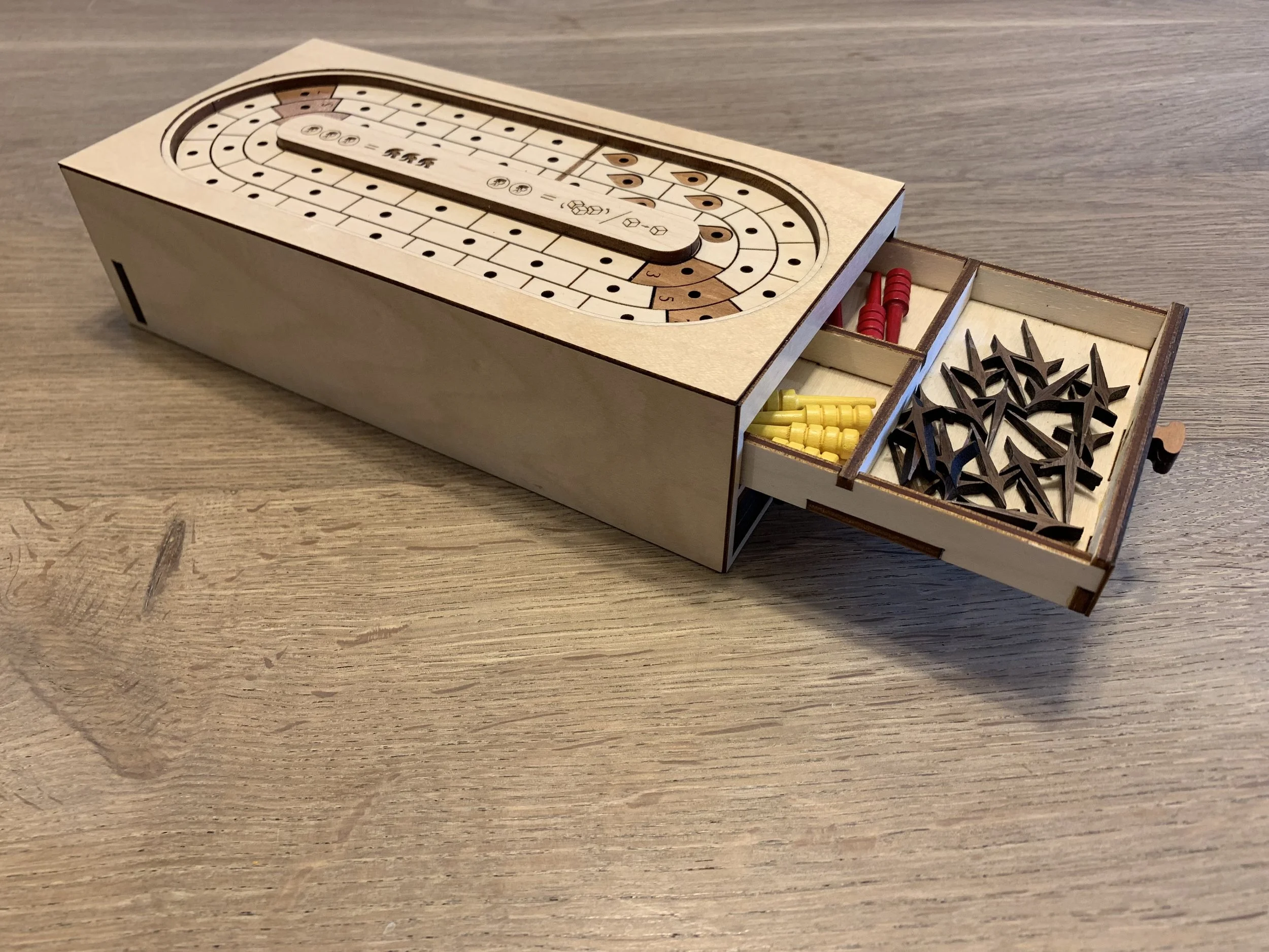 The drawer holds pegs for six players plus all the caltrops you’d ever need.