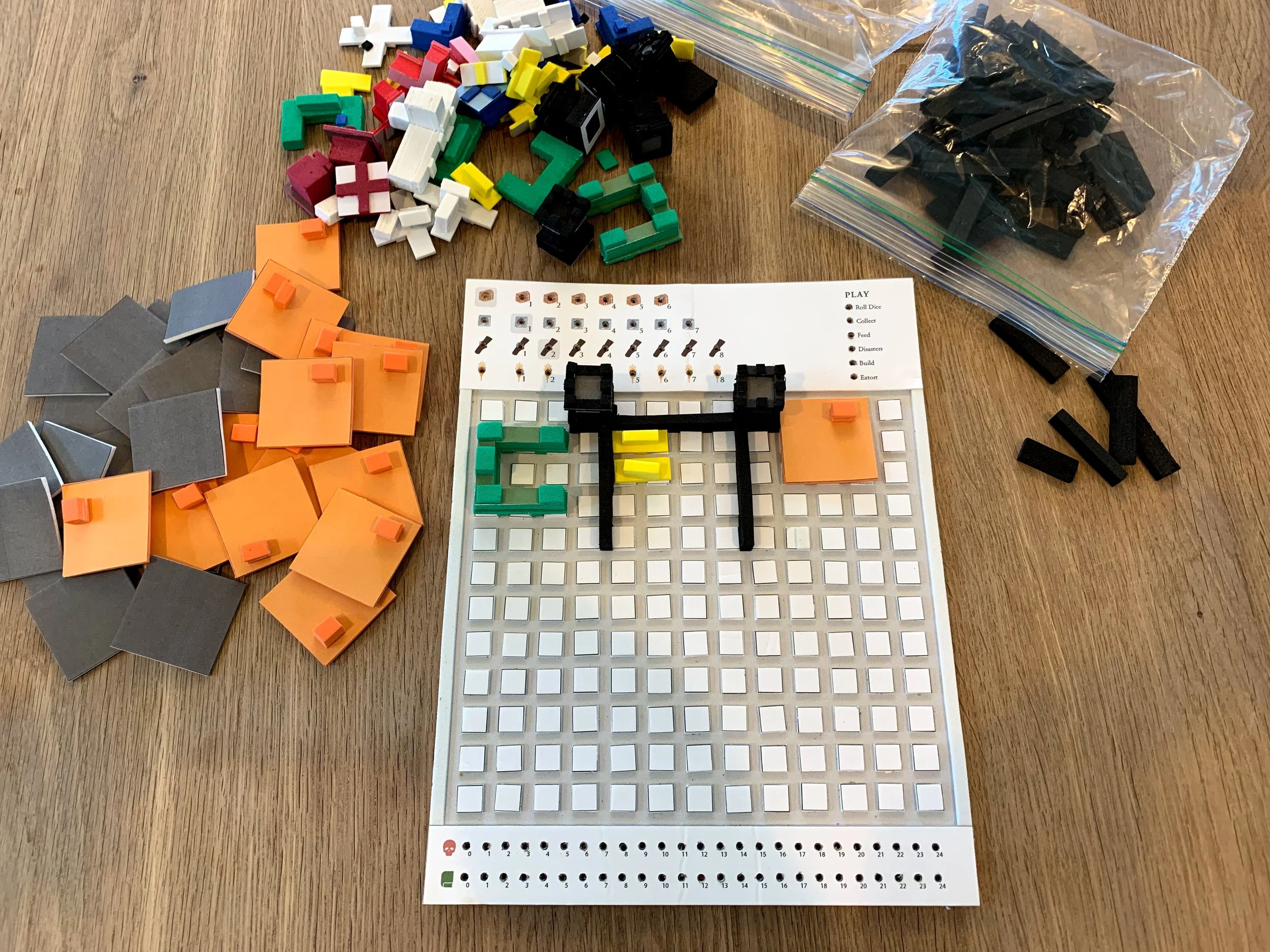 I actually used craft foam for my first 3D version of the board, which was a direct translation of the roll-and-write shapes: buildings went on squares; walls went between them. It looked promising. Testing soon showed, however, that players had a hard time figuring out how to place buildings on this grid.