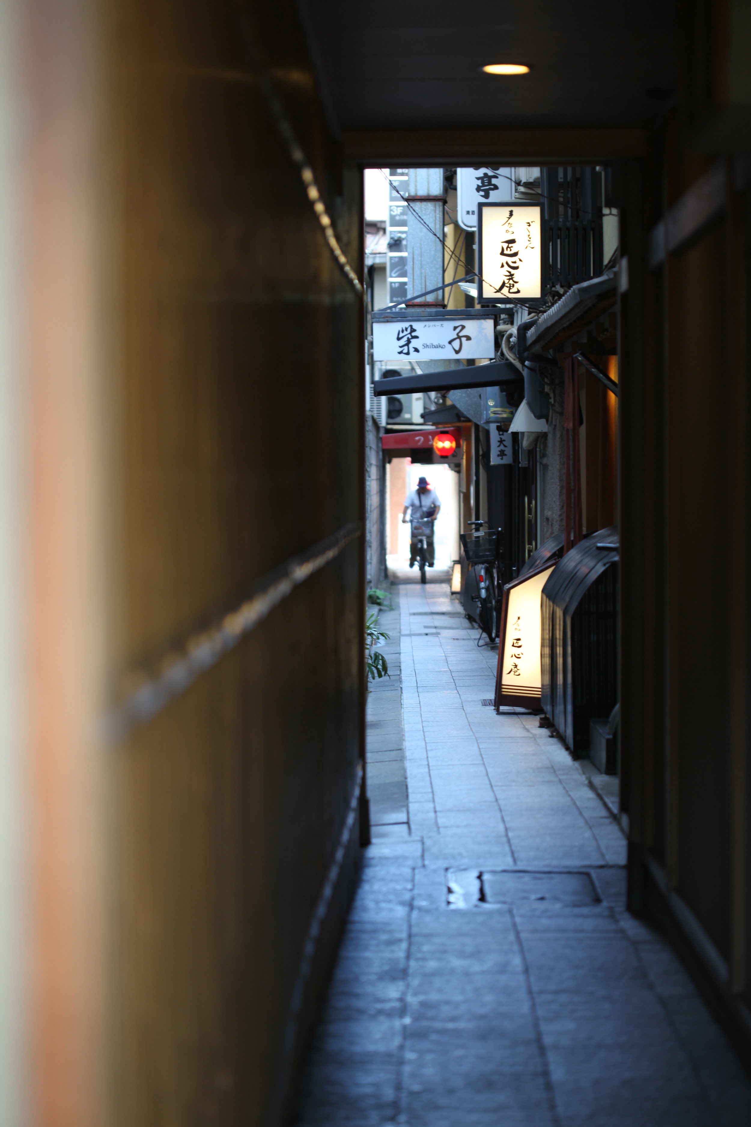 cycling through alley, kyoto, japan