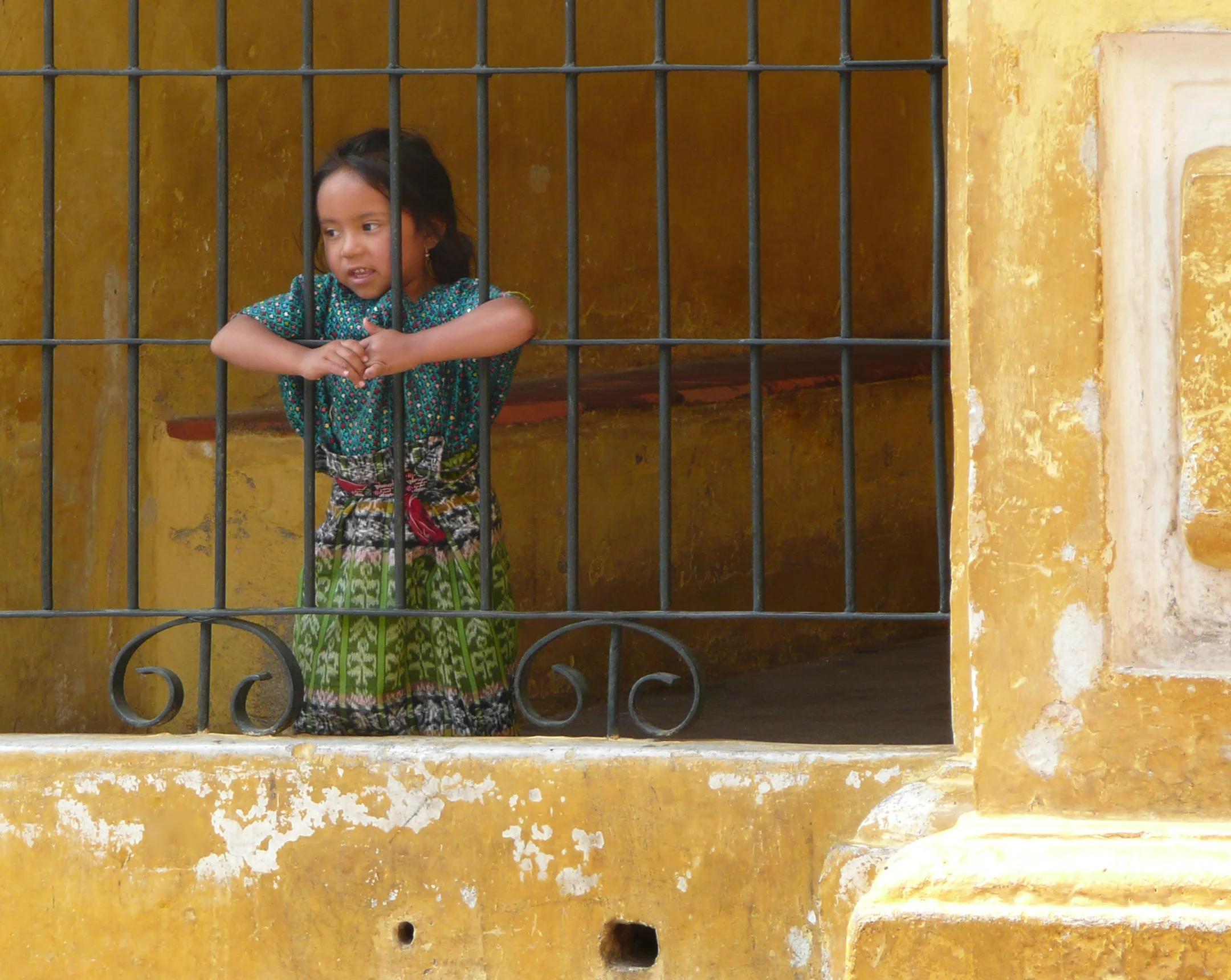 little girl behind bars, antigua, guatemala