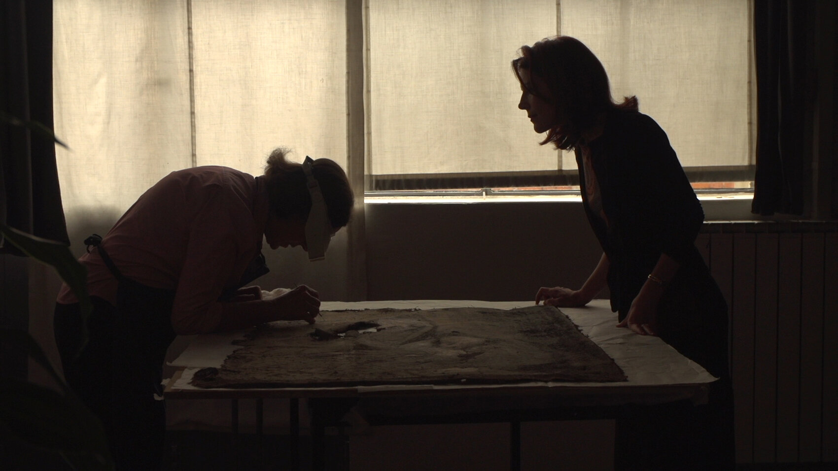 Lavoro investigativo in studio, con la restauratrice Rossella Lari e la direttrice di AWA Linda Falcone, che discutono sulle scoperte di un'opera incrostata di fango, arte vittima dell'alluvione del 1966 ancora in attesa di ‘guarigione’. (Foto: K. M