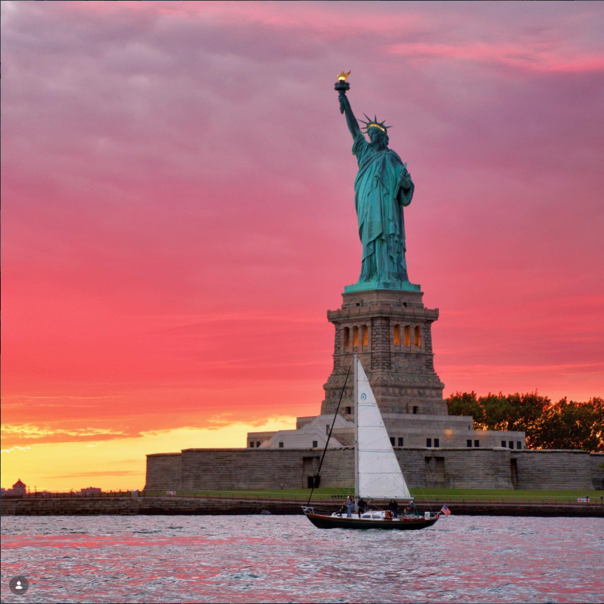 statue of liberty during sunset on the hudson river