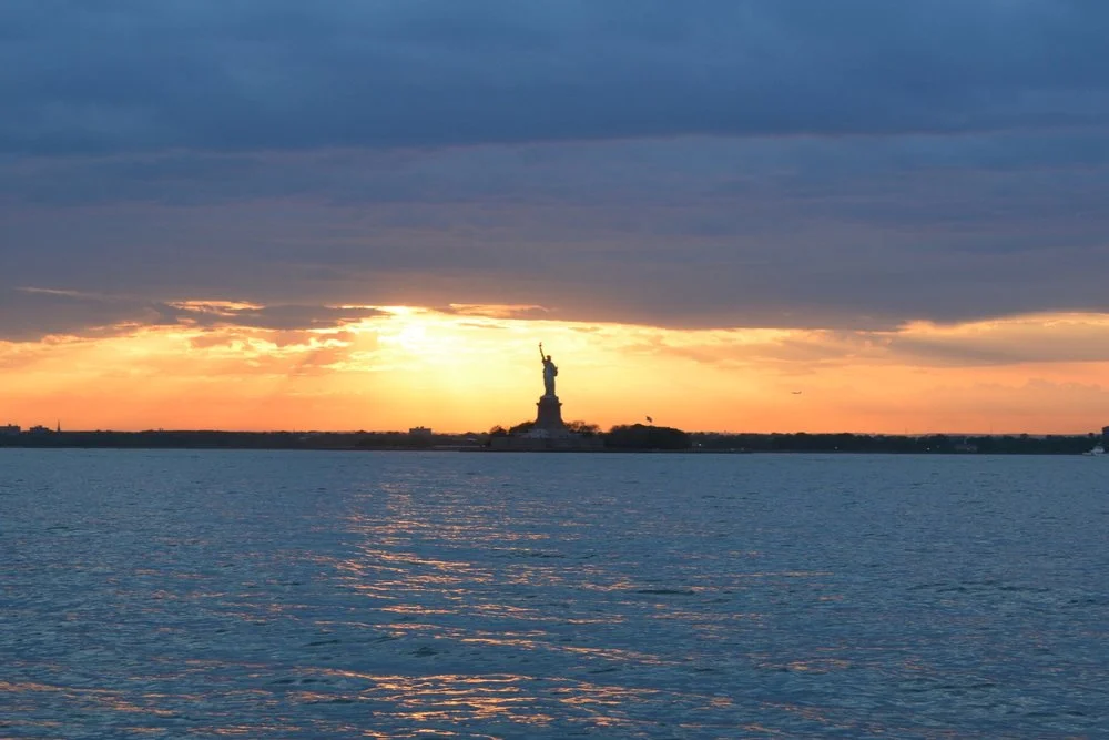 Catch a breathtaking view of the Statue of Liberty at sunset aboard a private tour.