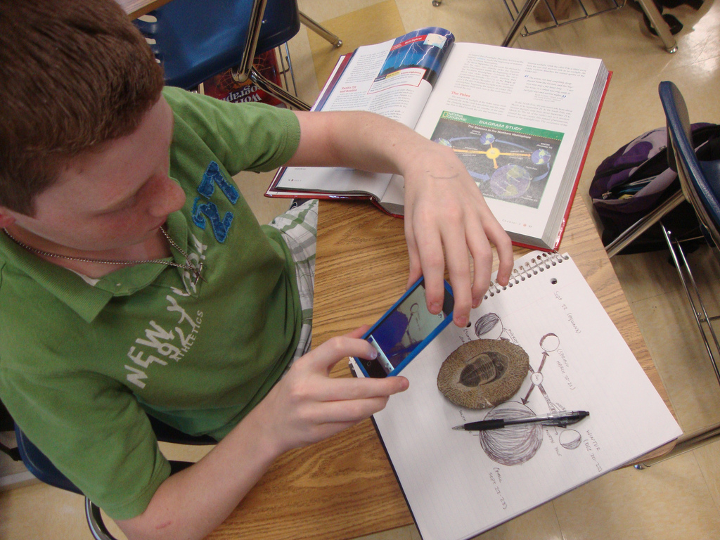 A student looks at a trilobite fossil during an SGS presentation at Caddo Magnet High School.