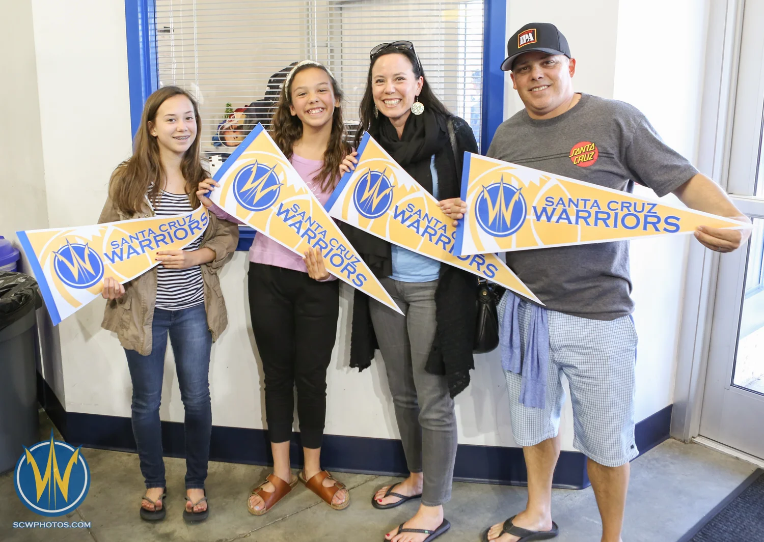 A family holds the Santa Cruz Warriors pennant flags given to them at the front doors at the Santa Cruz Warriors game on April 3, 2015 at Kaiser Permanente Arena in Santa Cruz, California. (Photo: Tim Cattera Photography/SC Warriors 2015)