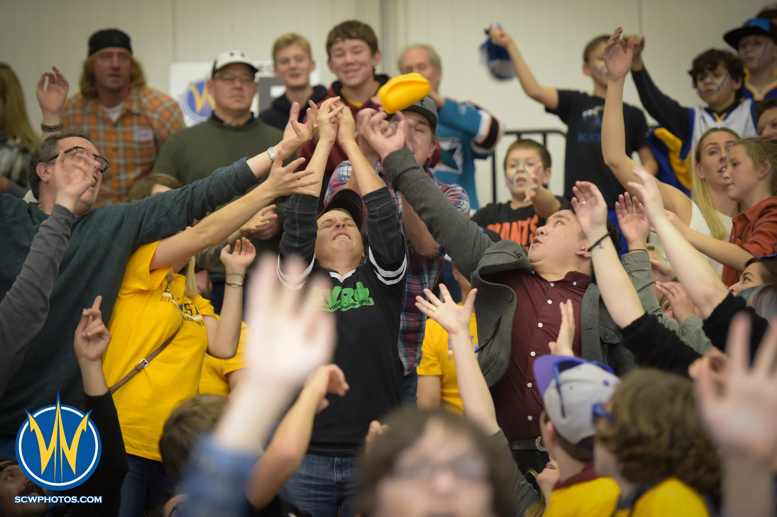 Warriors fans reaching out to grab one of the t-shirts thrown by the Pod Squad at the Santa Cruz Warrior game on 1/23/16 at Kaiser Permanente Arena in Santa Cruz California. (Phil Pasag/SC Warriors 2015)