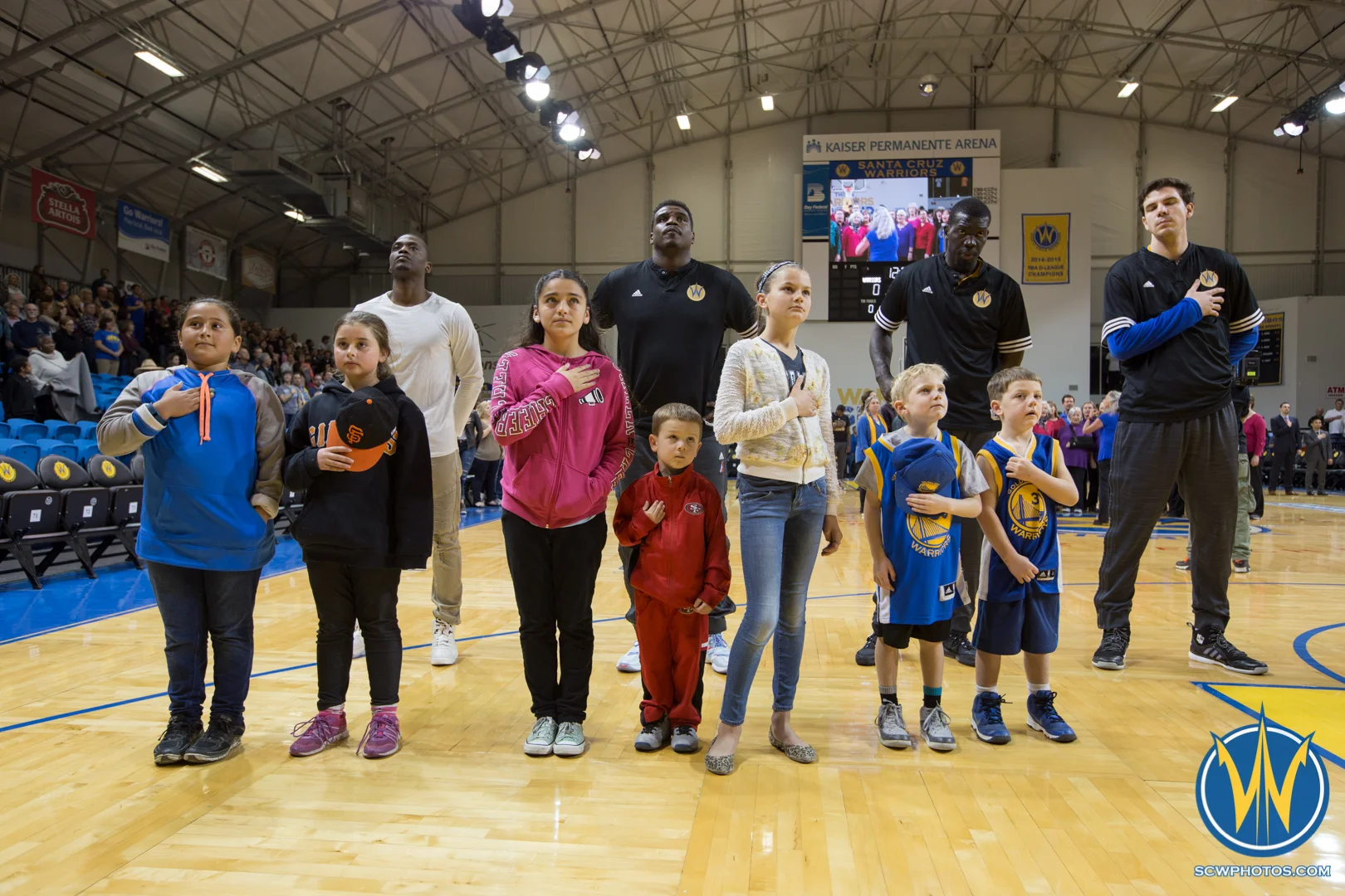 Young Santa Cruz Warriors fans stand with players during the National Anthem at Kaiser Permanente Arena on February 19, 2016 (Photo: Ariel Nava Photography)
