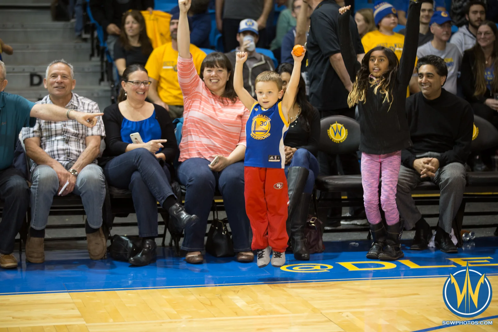A young fan in a Warriors jersey jumps up and down for a t-shirt at Kaiser Permanente Arena on February 19, 2016 (Photo: Ariel Nava Photography)