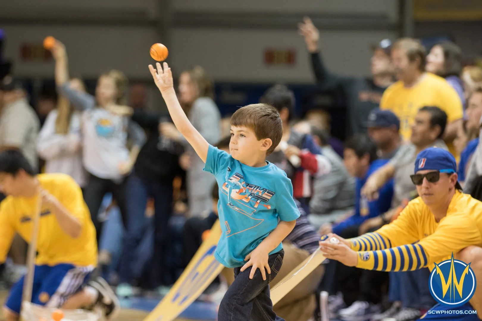 A young fan throws a ball for the Grind Out Hunger ball toss at Kaiser Permanente Arena on March 18, 2016 (Photo: Ariel Nava Photography)