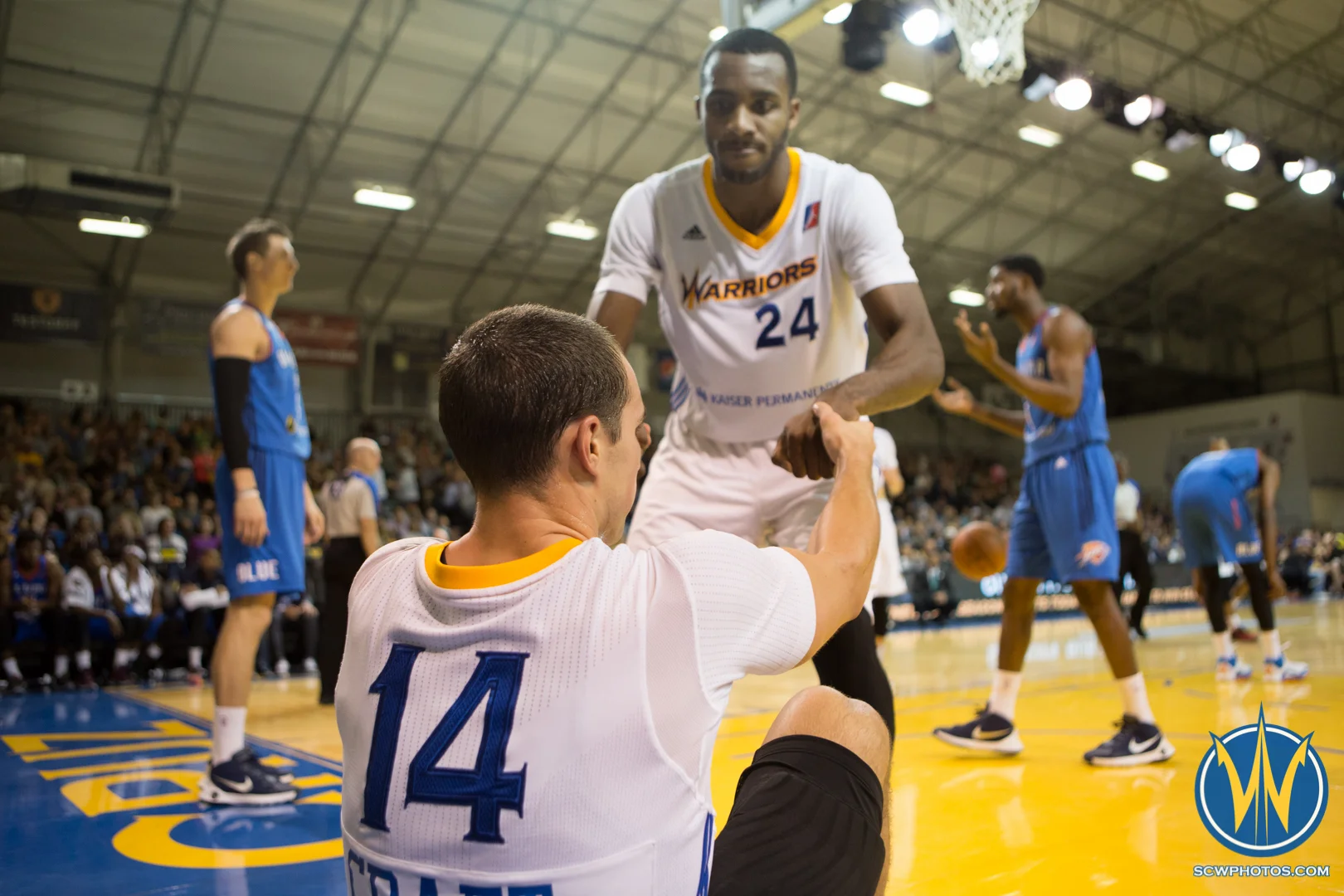 Chris Udofia helps Aaron Craft up off the floor at Kaiser Permanente Arena on March 18, 2016 (Photo: Ariel Nava Photography)