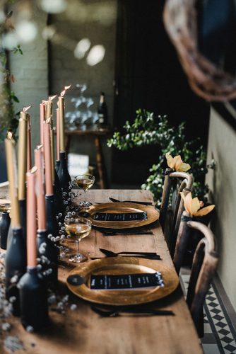 wedding-trends-2019-moody-table-with-candles-in-bottles-with-flowers-and-gold-plates-cj-williams-334x500.jpg