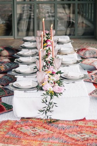 wedding-trends-2019-low-boho-table-pillows-around-eclectic-pink-glasses-candles-flowers-and-greenery-ugophotography-334x500.jpg