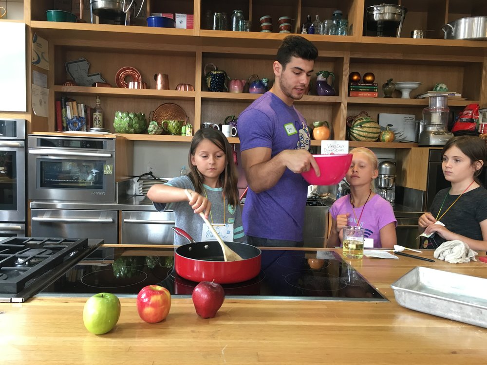 Jake helping with cooking Martine on stove.jpeg