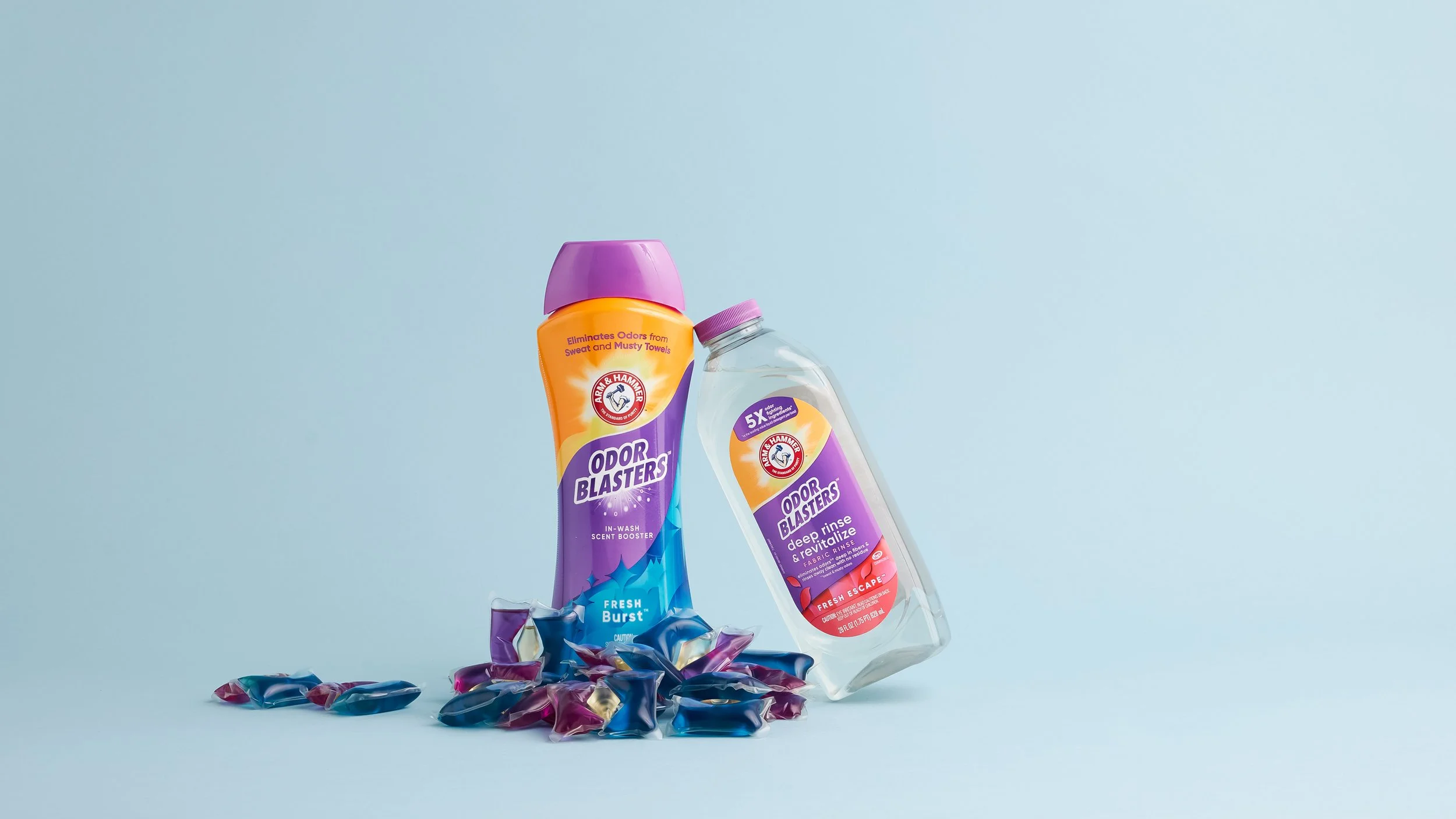 Arm & Hammer Odor Blasters cleaning products with candies on light blue background.