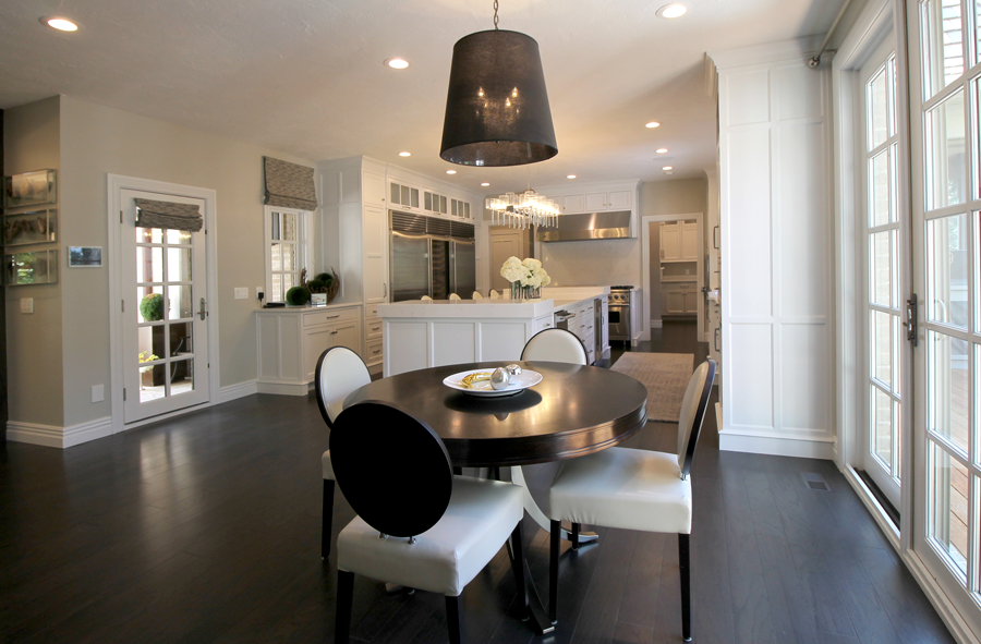 The kitchen is home to stunning features, including beautiful new lighting in the form of the dramatic chrome and glass island pendant, which is contrasted by the dark drum fixture hanging above the breakfast table. 