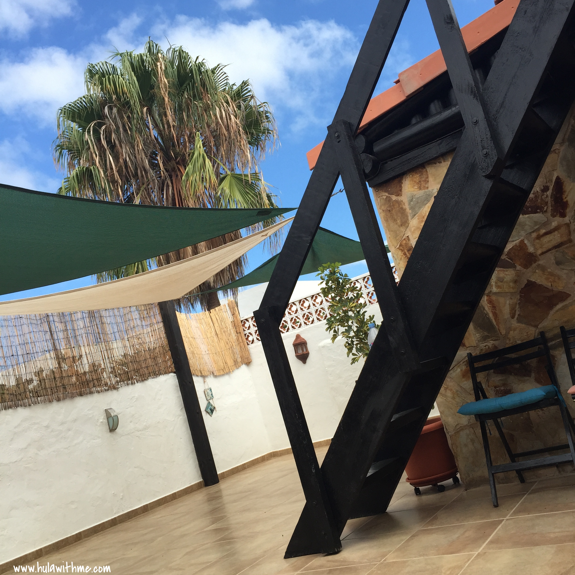We practice in the evening in this open space. As we move through our poses, we are gently pushed by the sounds of the wind chimes and the palm trees swaying above us.