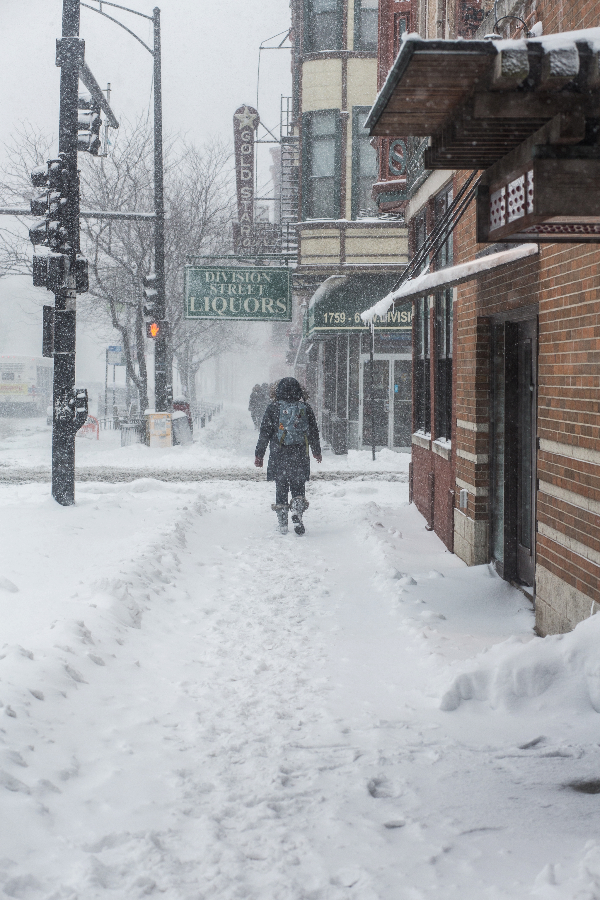 A woman hikes East on W. Division Street during Winter Storm Linus.