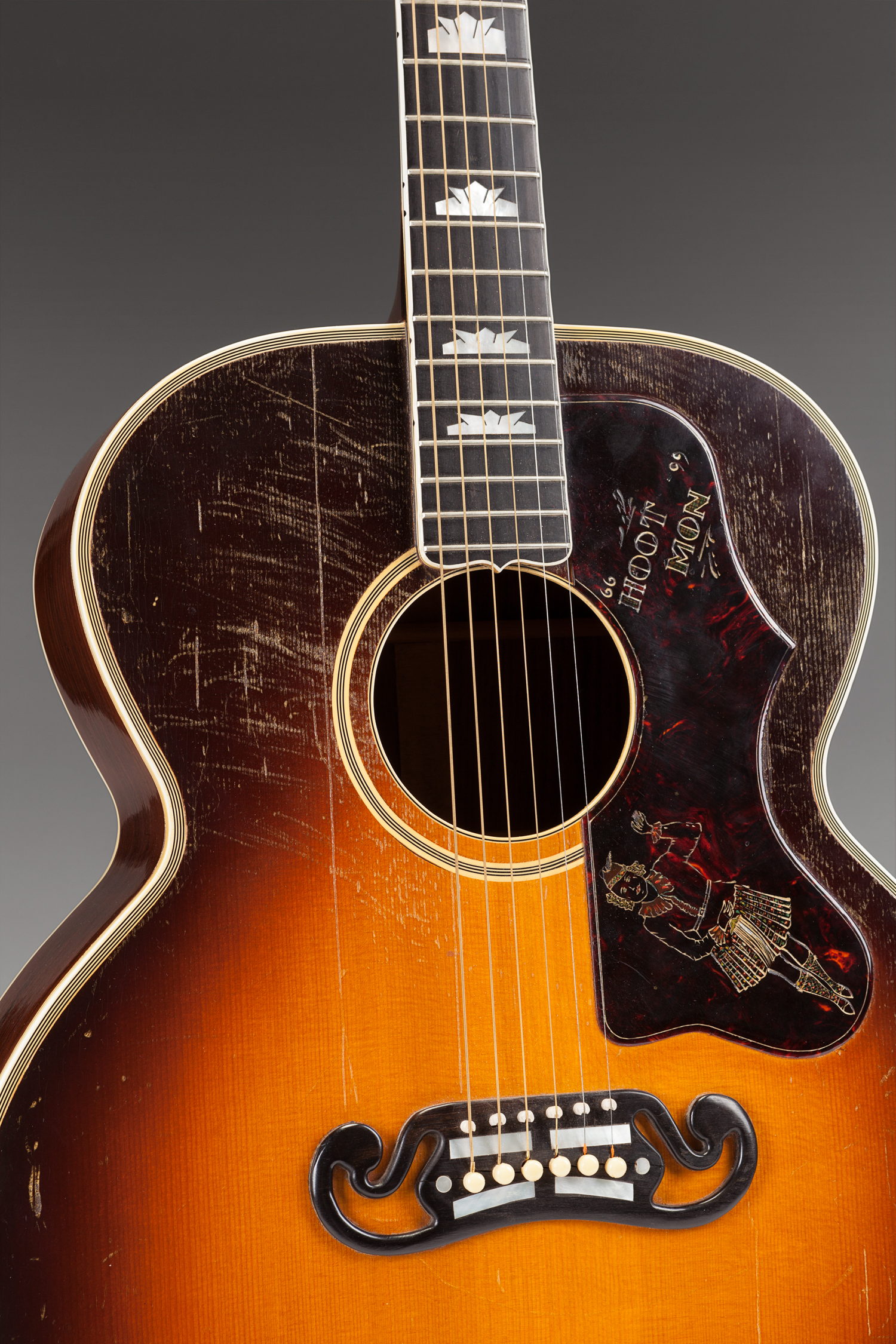 "Hoot Mon" engraved on the pick guard roughly translates from Scottish to "Hey Man." The dancing Scottish figure reflects Peggy Eames' talent for the Scottish dancing style.