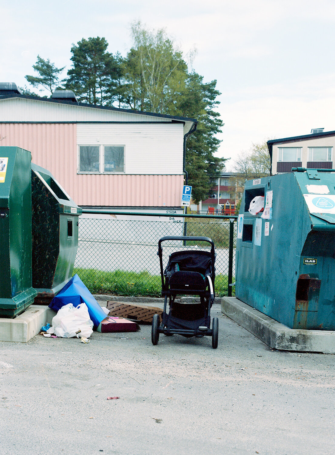 Återvinningsstationer, med barnvagn lämnad mellan