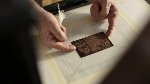 Placing the inked and wiped plate on the bed of the press