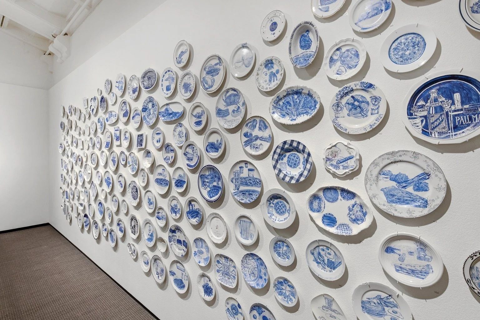 Painted plants hung on the wall of an art gallery