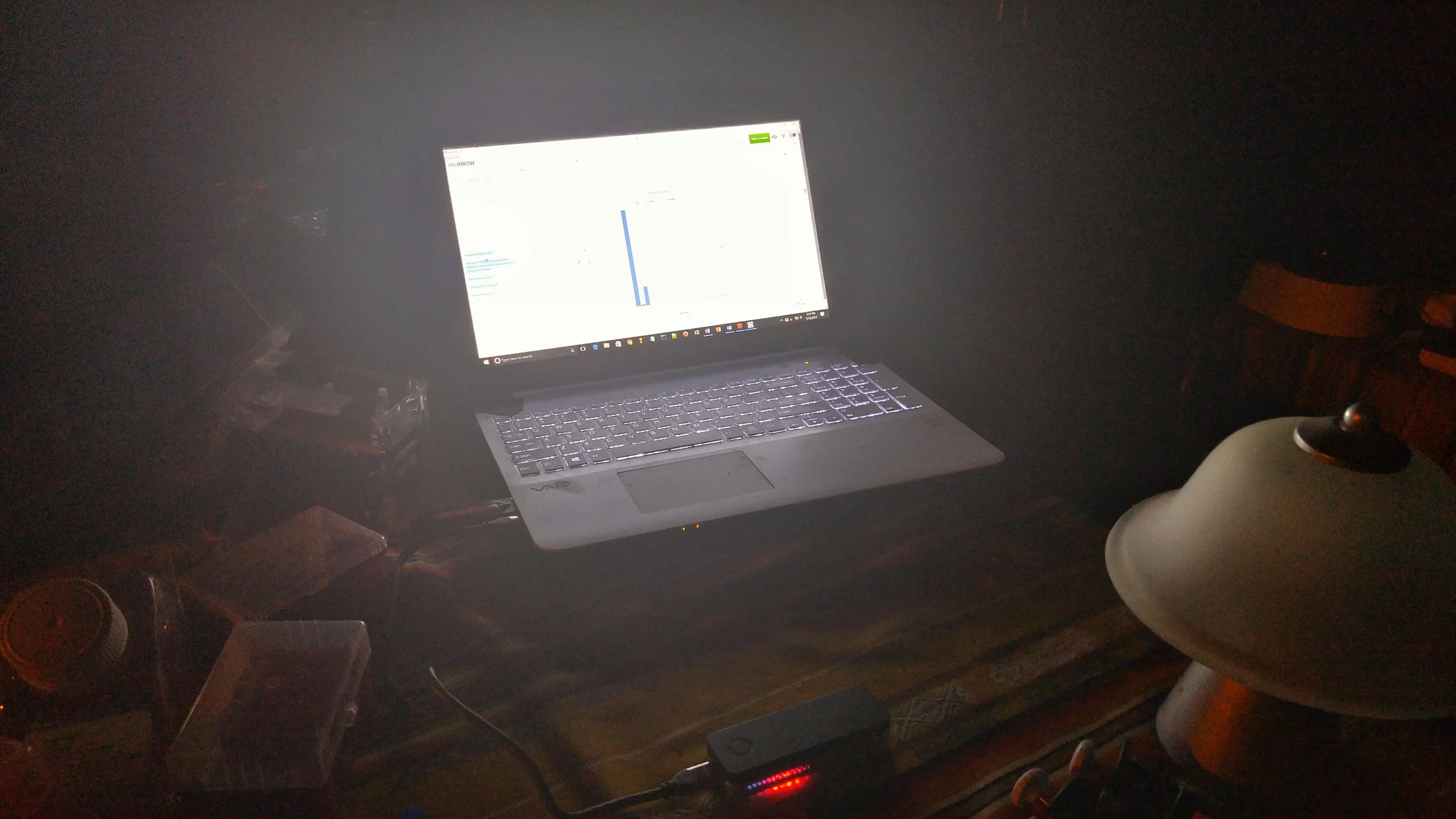 The MinION sequencer glowing red and blue as it runs off the power of my laptop.