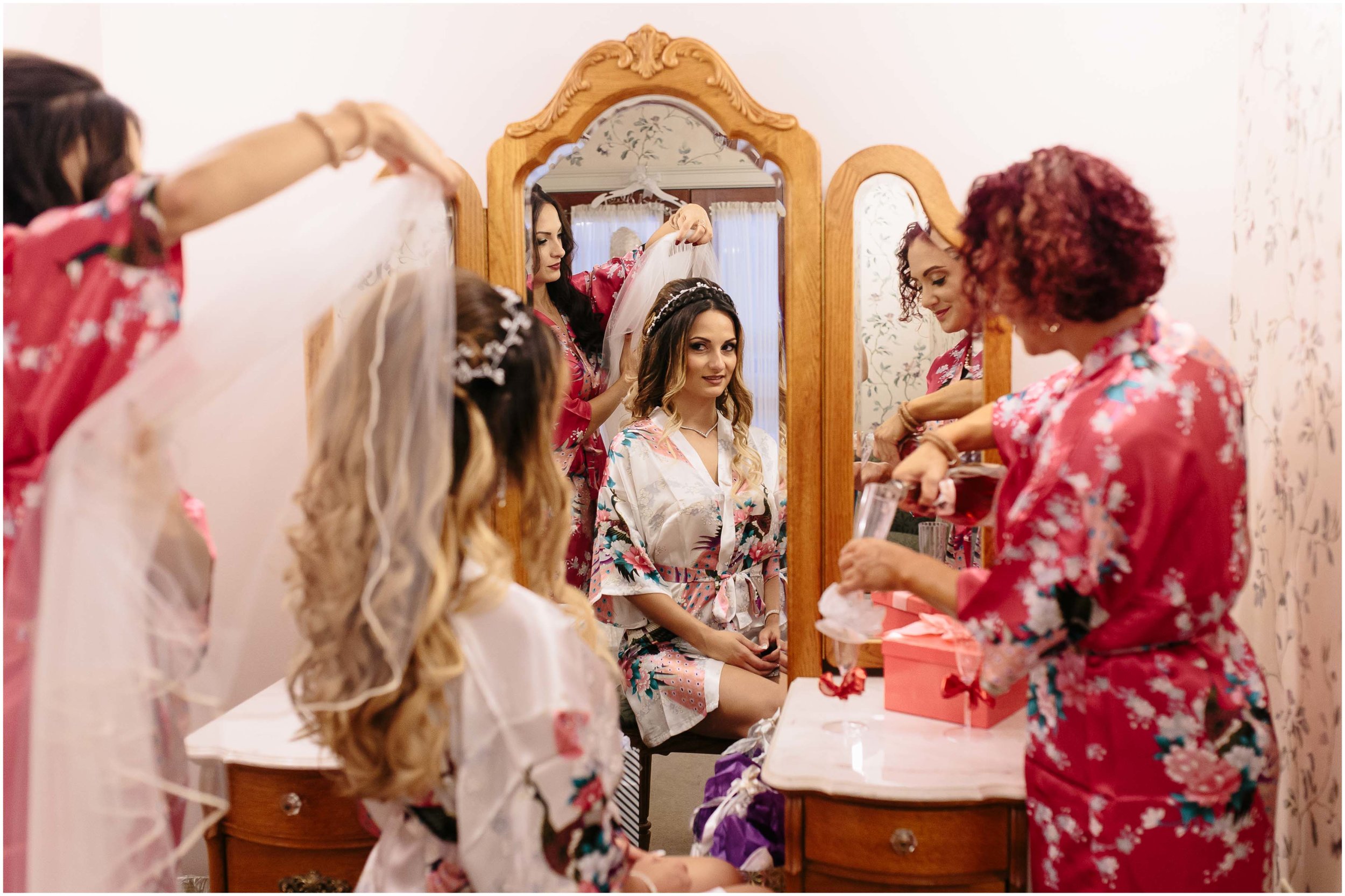 Scenic New Hampshire Wedding at Atkinson Resort and Country Club - Bridesmaid/Maid of honor putting veil on bride