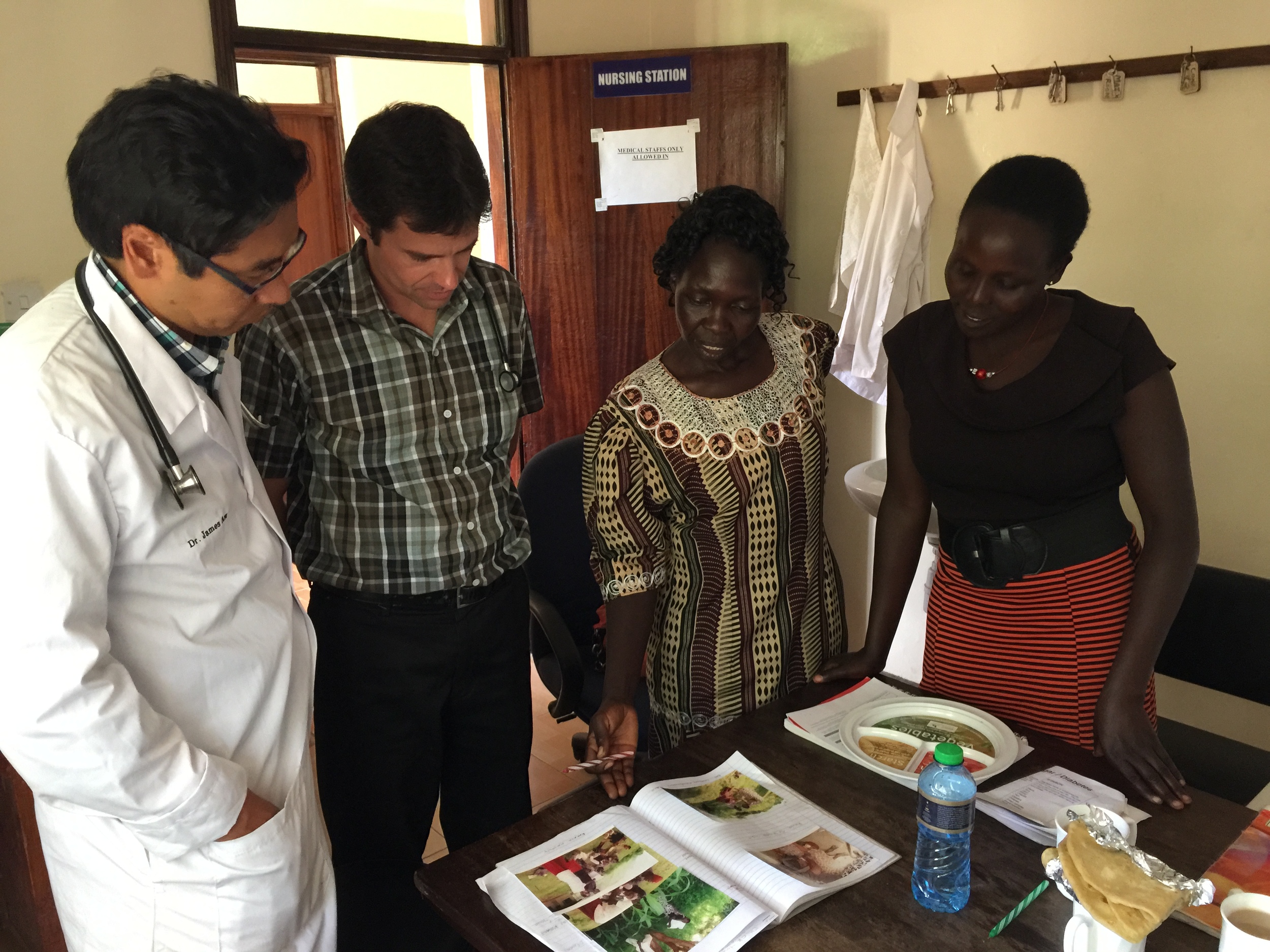Helen and Faith share their record books on their chronic disease patients with Dr. James and Dr. Michael. 