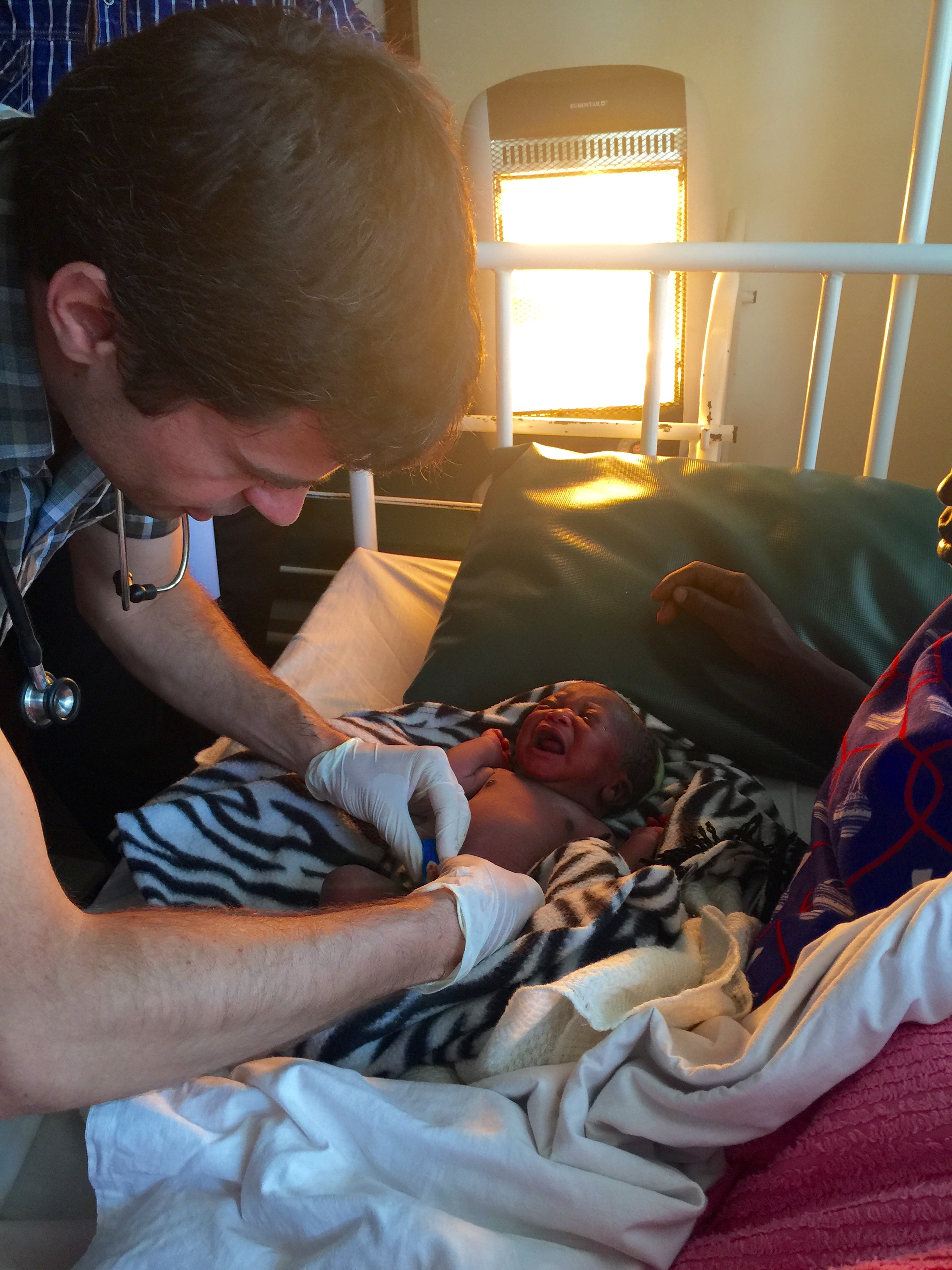 Dr. Michael demonstrates one final neo-natal exam in the perfectly healthy baby boy. 