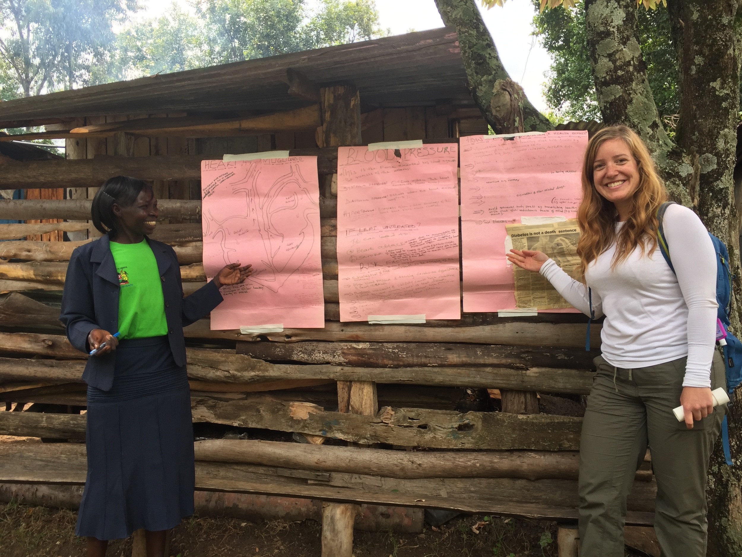 Helen showing Vanessa and me her self made chronic disease posters that she uses when travelling in her community identifying people at risk for chronic diseas 