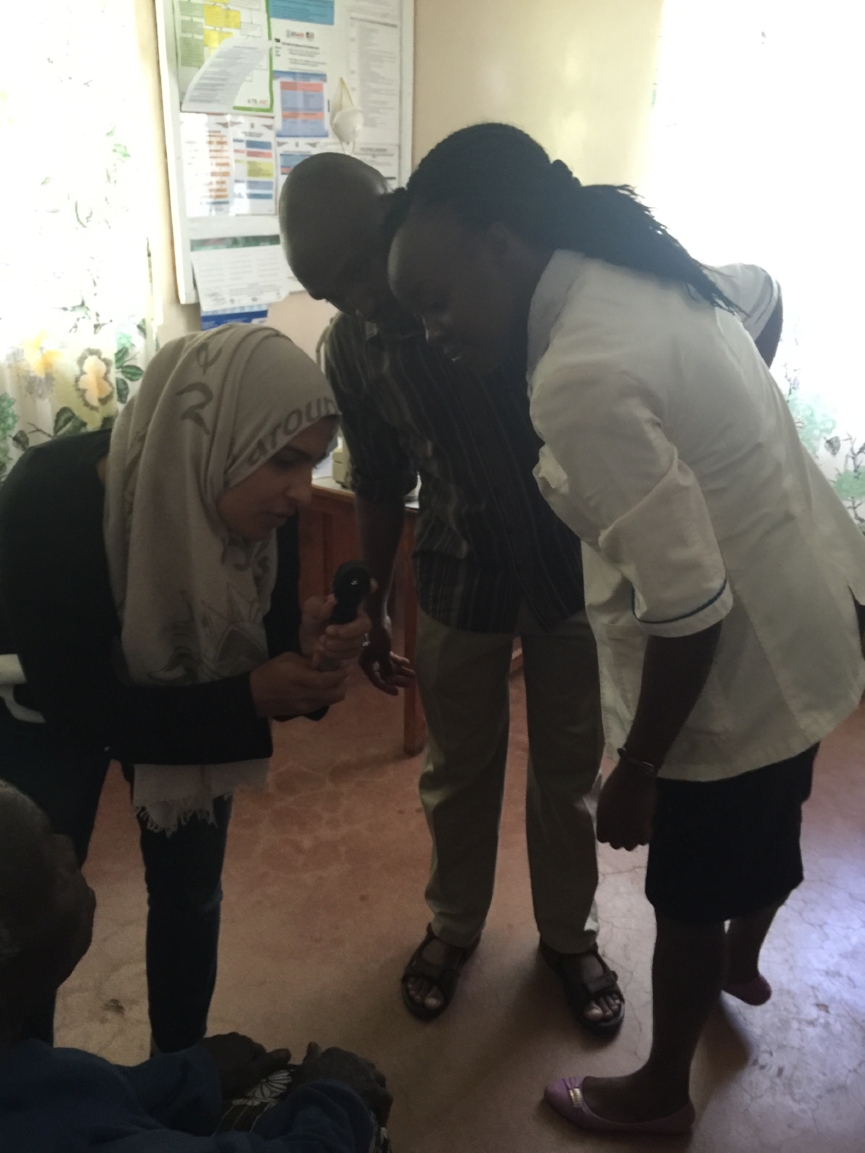 Dr. Sidiqa training Noah and Jemimah on the ophthalmoscop 