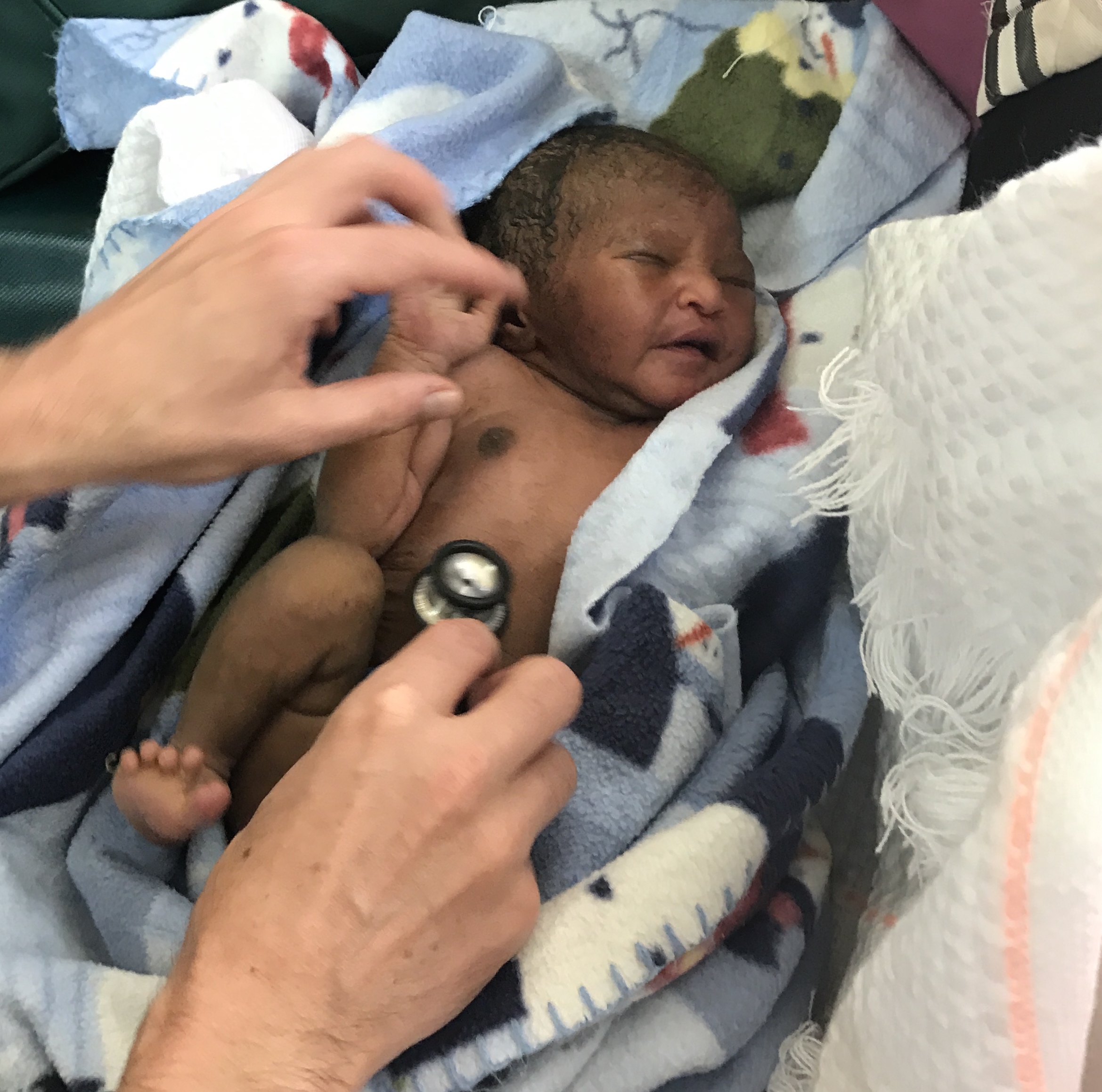 Dr. Michael demonstrating a neonatal examination on the newborn baby of the asthmatic mother.