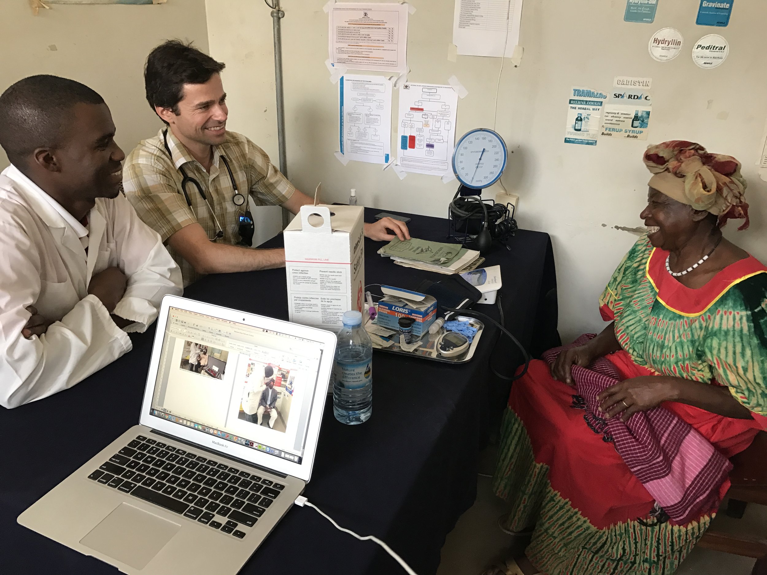 Dr. Michael working with a nurse at the hospital while seeing a chronic disease patient.