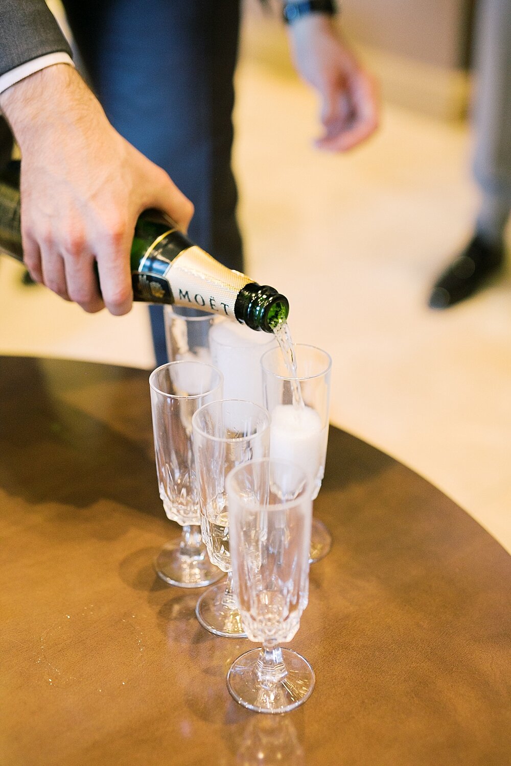 groom pours a glass of champagne before NY wedding