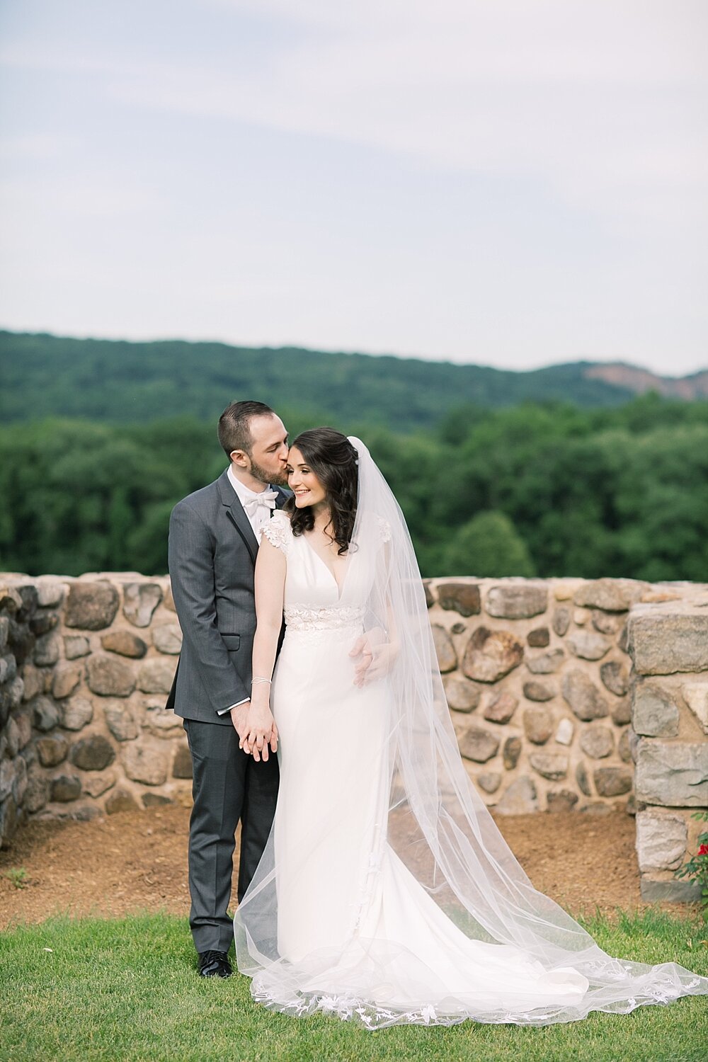 bride with cathedral veil and groom pose at Paramount Country Club