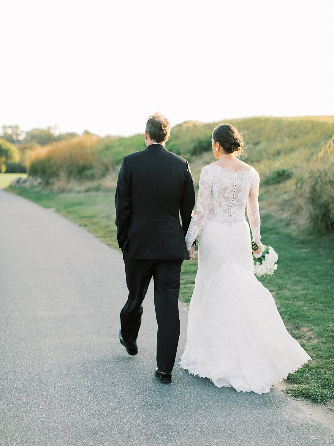 bride and groom walk on golf course at 360 Downs with Asher Gardner Photography