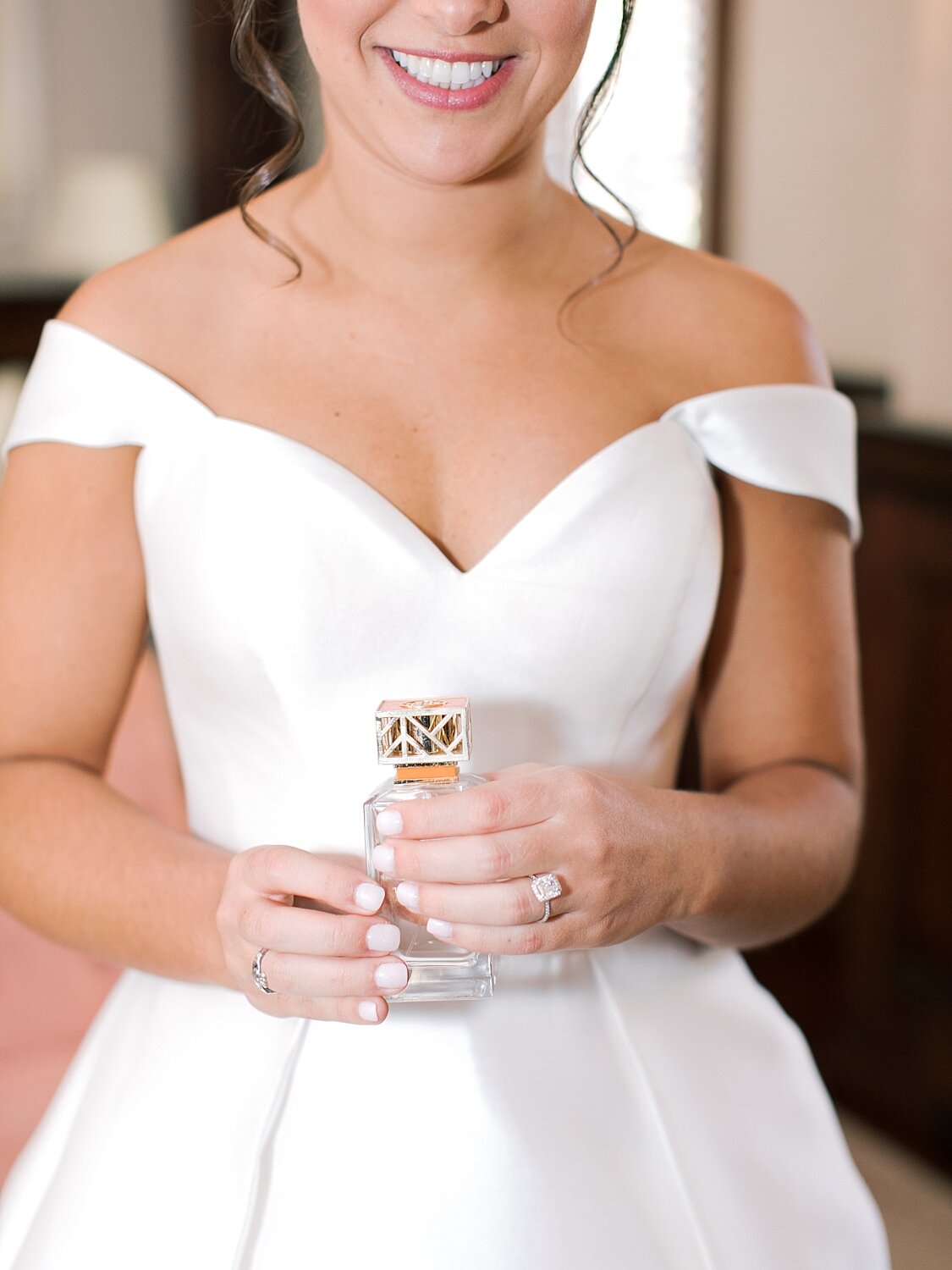 bride holds perfume for NY wedding day with Asher Gardner Photography
