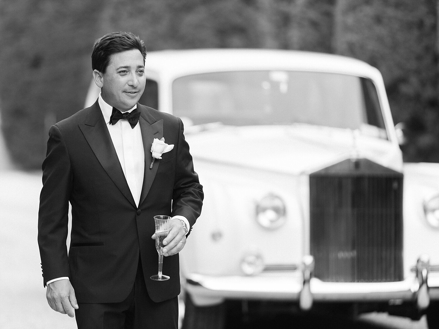 groom poses by classic car for Asher Gardner Photography