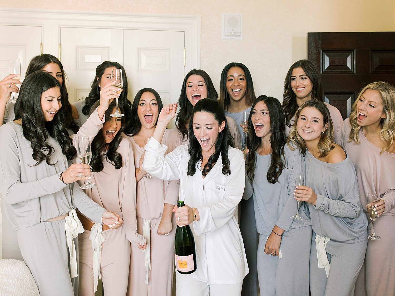bride pops champagne with bridesmaids | Stylish Private Home Wedding Inspiration | Asher Gardner Photography