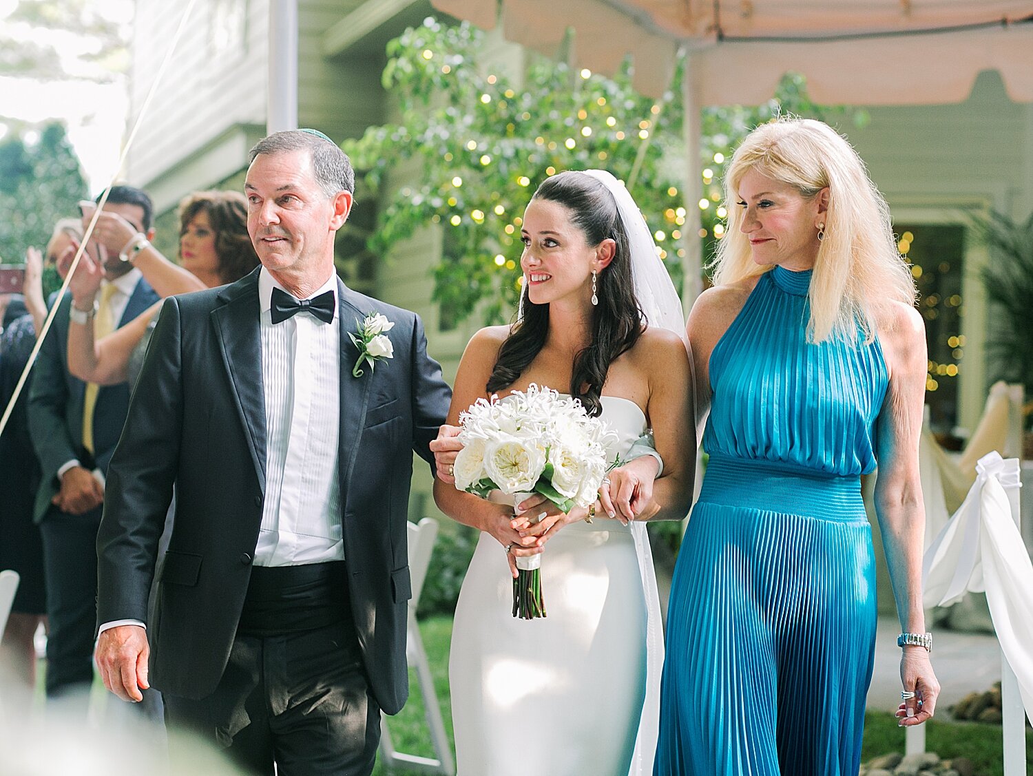 bride walks down aisle with parents during Jewish wedding ceremony | Stylish Private Home Wedding Inspiration | Asher Gardner Photography