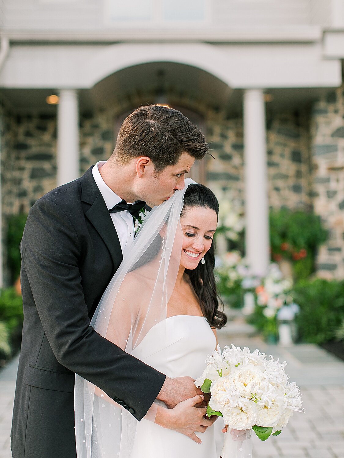 groom kisses bride's forehead during photos after NY wedding | Stylish Private Home Wedding Inspiration | Asher Gardner Photography
