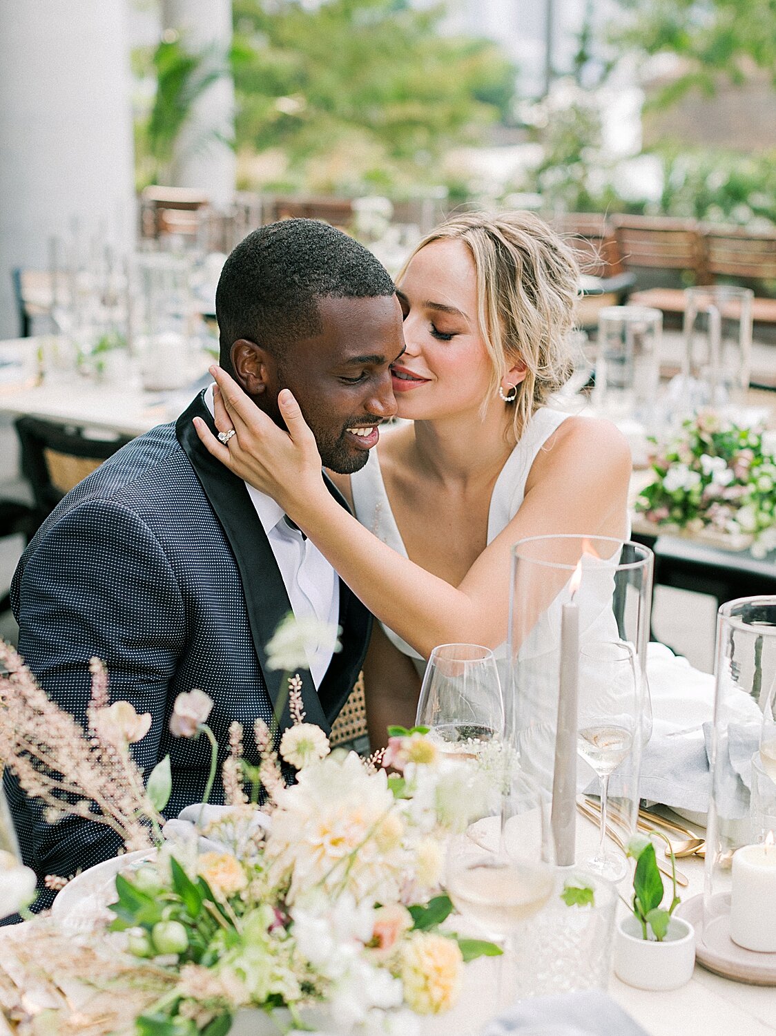 newlyweds kiss at table during NYC wedding reception | Asher Gardner Photography | Intimate Ceremony in DUMBO New York 