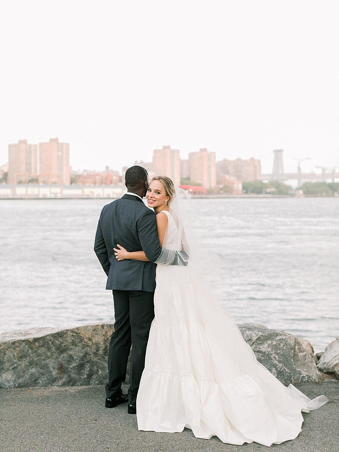bride and groom pose by Hudson River | Asher Gardner Photography | Intimate Ceremony in DUMBO New York
