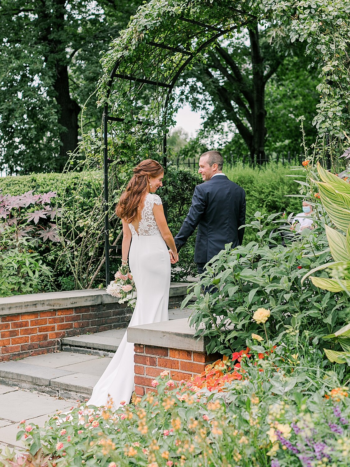 newlyweds walk under arch in Central Park Conservatory Gardens | Asher Gardner Photography | Elopement at the Central Park Conservatory Gardens