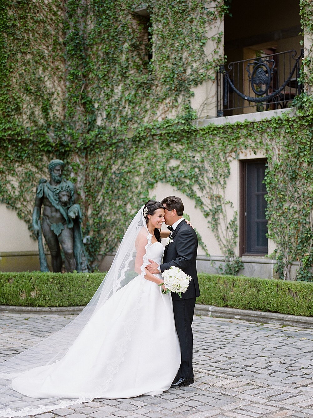 newlyweds pose by ivy covered wall at Oheka Castle | Tri-State Area Wedding Venues photographed by NY wedding photographer Asher Gardner Photography