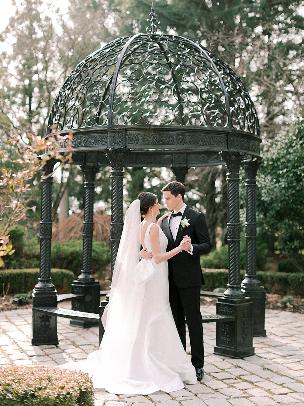 newlyweds kiss by gazebo at sophisticated New Jersey venue | Tri-State area wedding venues photographed by Asher Gardner Photography