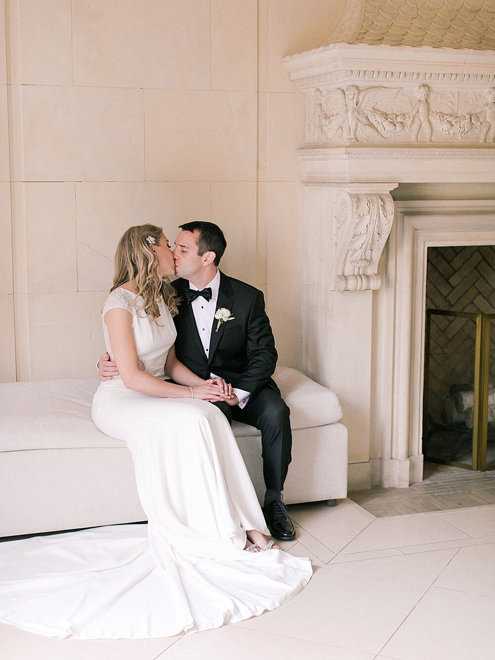 couple kisses on bench in Natirar Mansion | Tri-State area wedding venues photographed by Asher Gardner Photography