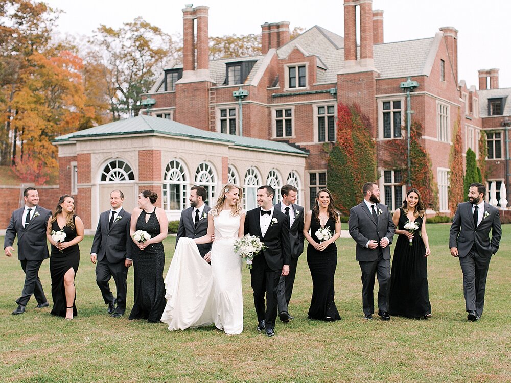 wedding party walks along lawn at Natirar Mansion | Tri-State area wedding venues photographed by Asher Gardner Photography