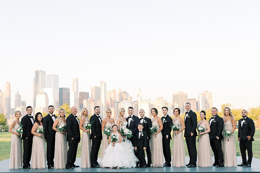 bridal party poses with New York City skyline behind them at Liberty House | Tri-State area wedding venues photographed by Asher Gardner Photography